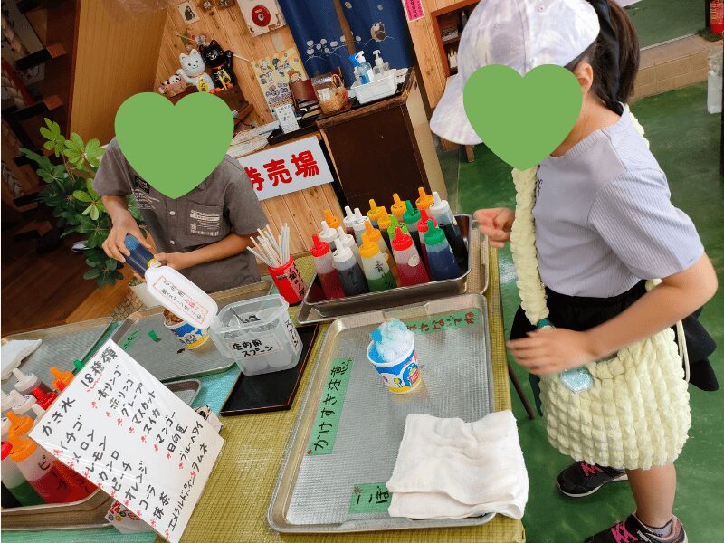 法多山参道のお店でかき氷にシロップをかける子どもたち